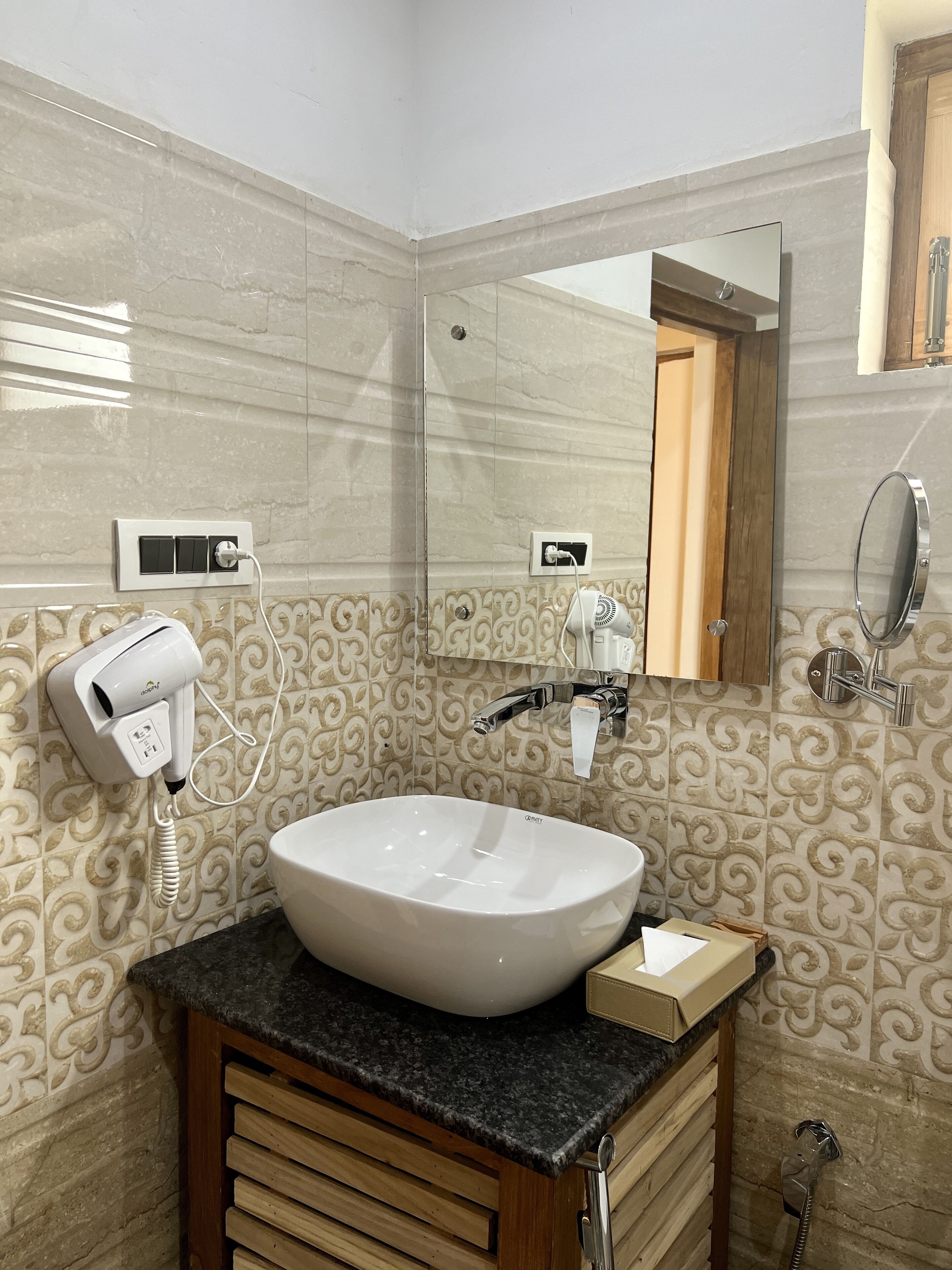 Un baño con lavamanos blanco, secador de pelo y espejo.