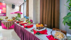 A buffet table with various food items and a decorative pumpkin centerpiece. - Ming Hua Hotel (Aksu)