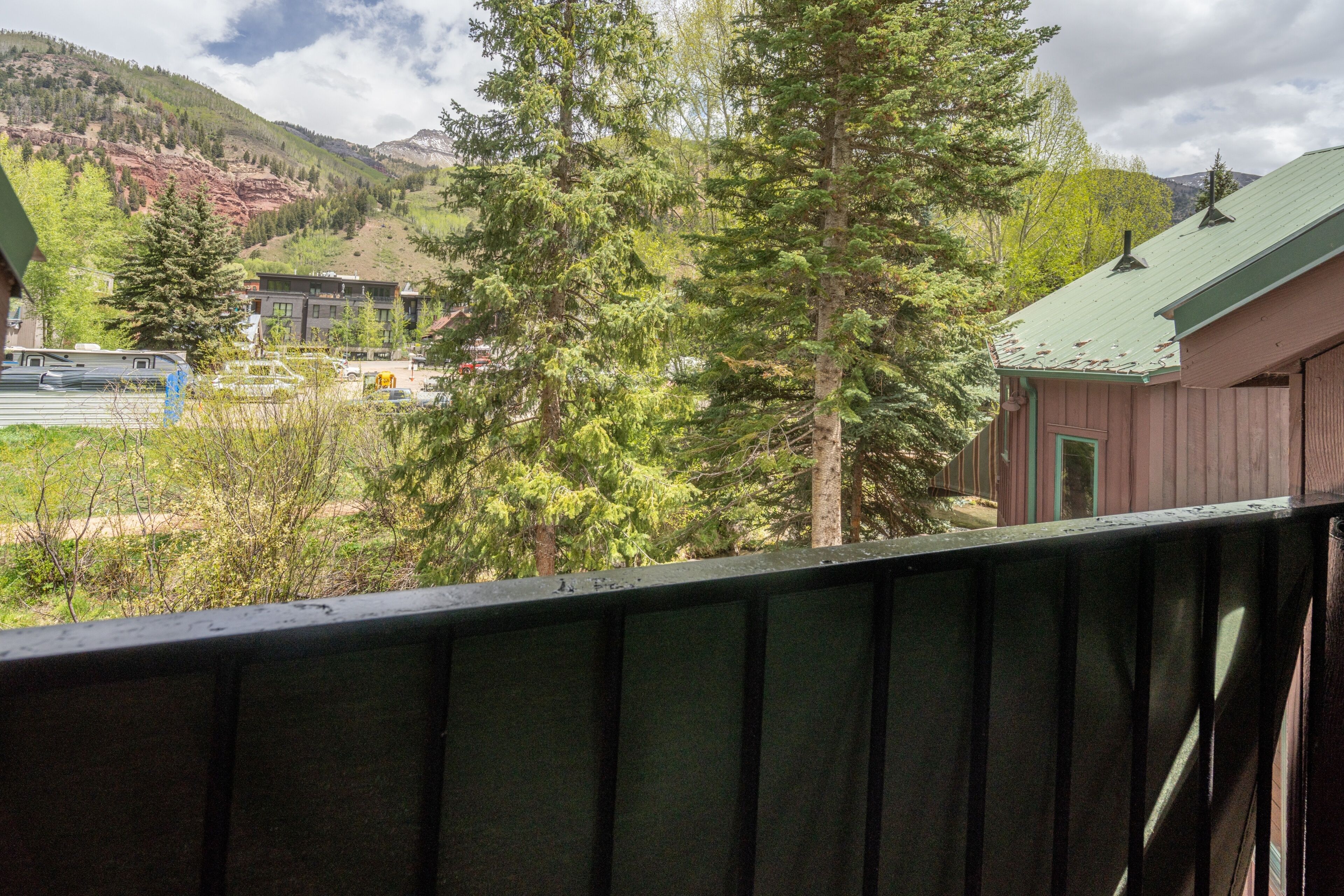 A mountain view with a cabin and a bus in the foreground.