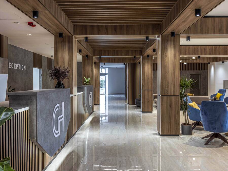 Un área de recepción moderna con mostrador de recepción, una computadora Dell y una barra de atención al cliente.