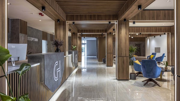 Un área de recepción moderna con mostrador de recepción, una computadora Dell y una barra de atención al cliente.