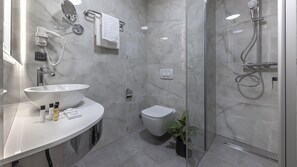 A modern bathroom with a sink, toilet, and shower.