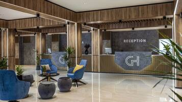 Un área de recepción moderna con paneles de madera, una mesa de recepción y disposición de asientos.