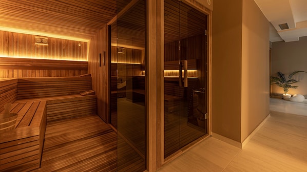 A modern sauna with wooden benches and glass doors, a clock on the wall, and a potted plant in the corner.