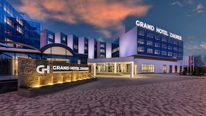 The Grand Hotel Zagreb with a modern glass facade, a stone entrance, and a well-lit entrance area.