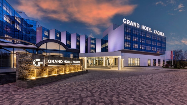 The Grand Hotel Zagreb with a modern glass facade, a stone entrance, and a well-lit entrance area.