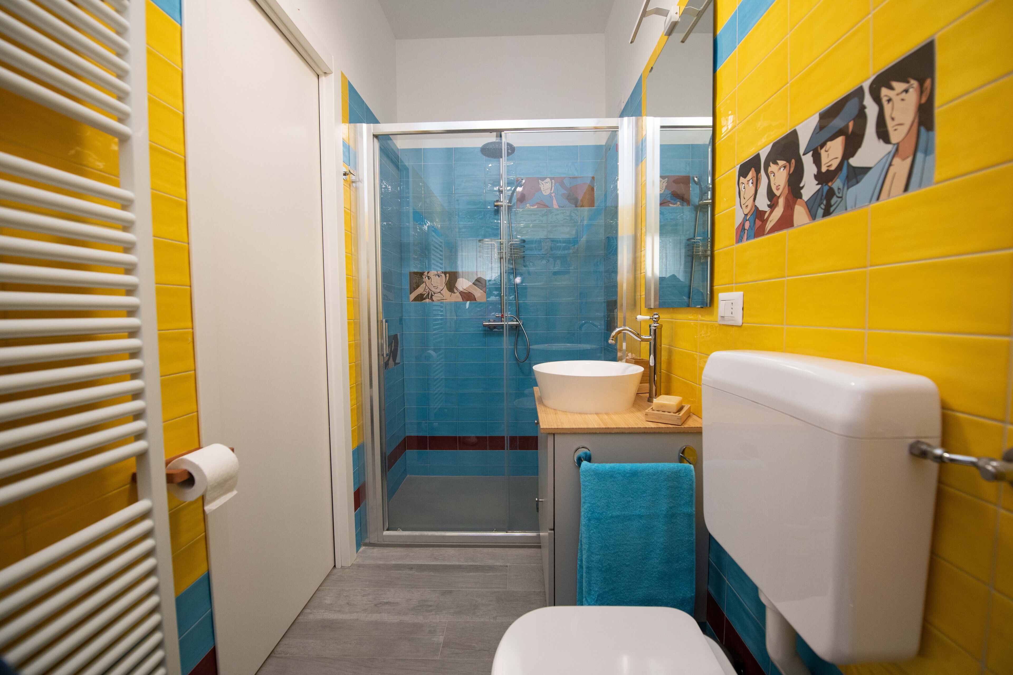 Une salle de bain avec une douche à parois de verre, un lavabo blanc et des toilettes.