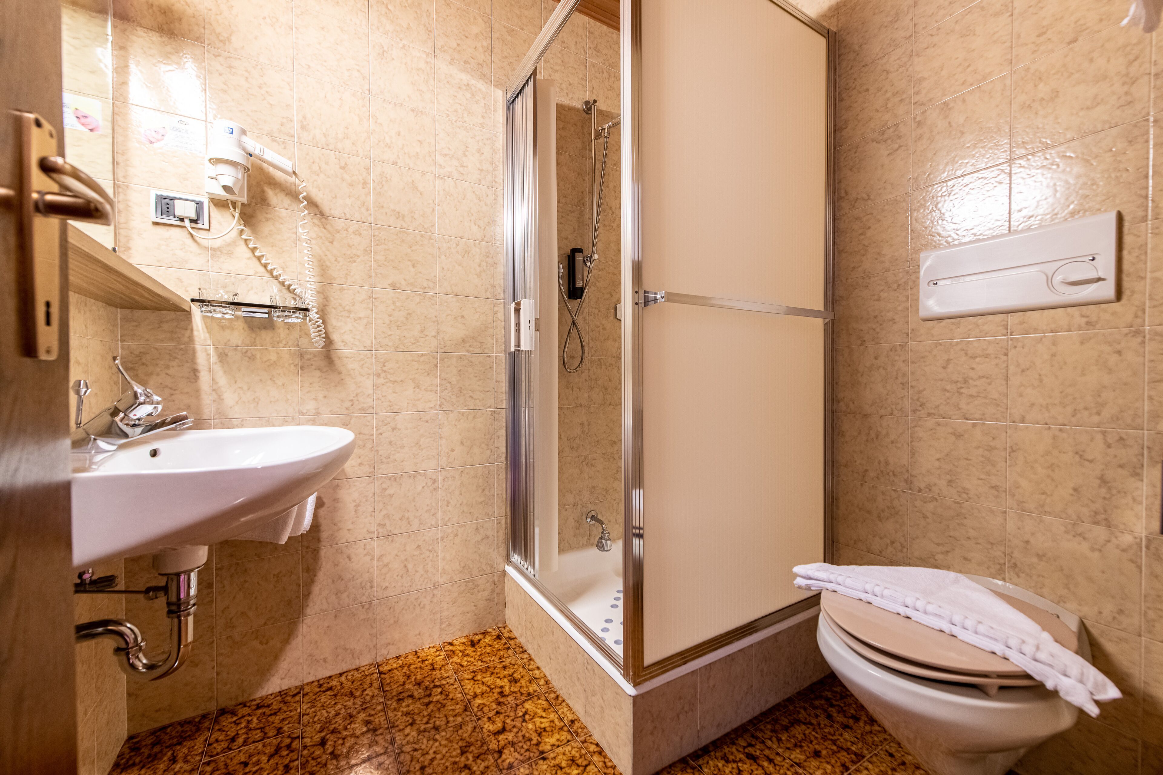 Un baño con lavamanos, inodoro y ducha.