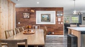 Un comedor con una mesa de madera, sillas y un centro decorativo.