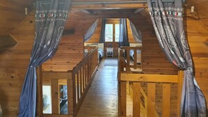 A wooden interior with a loft bedroom and a staircase.