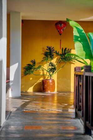 A hallway with a potted plant and a decorative ornament above, set against a neutral background.