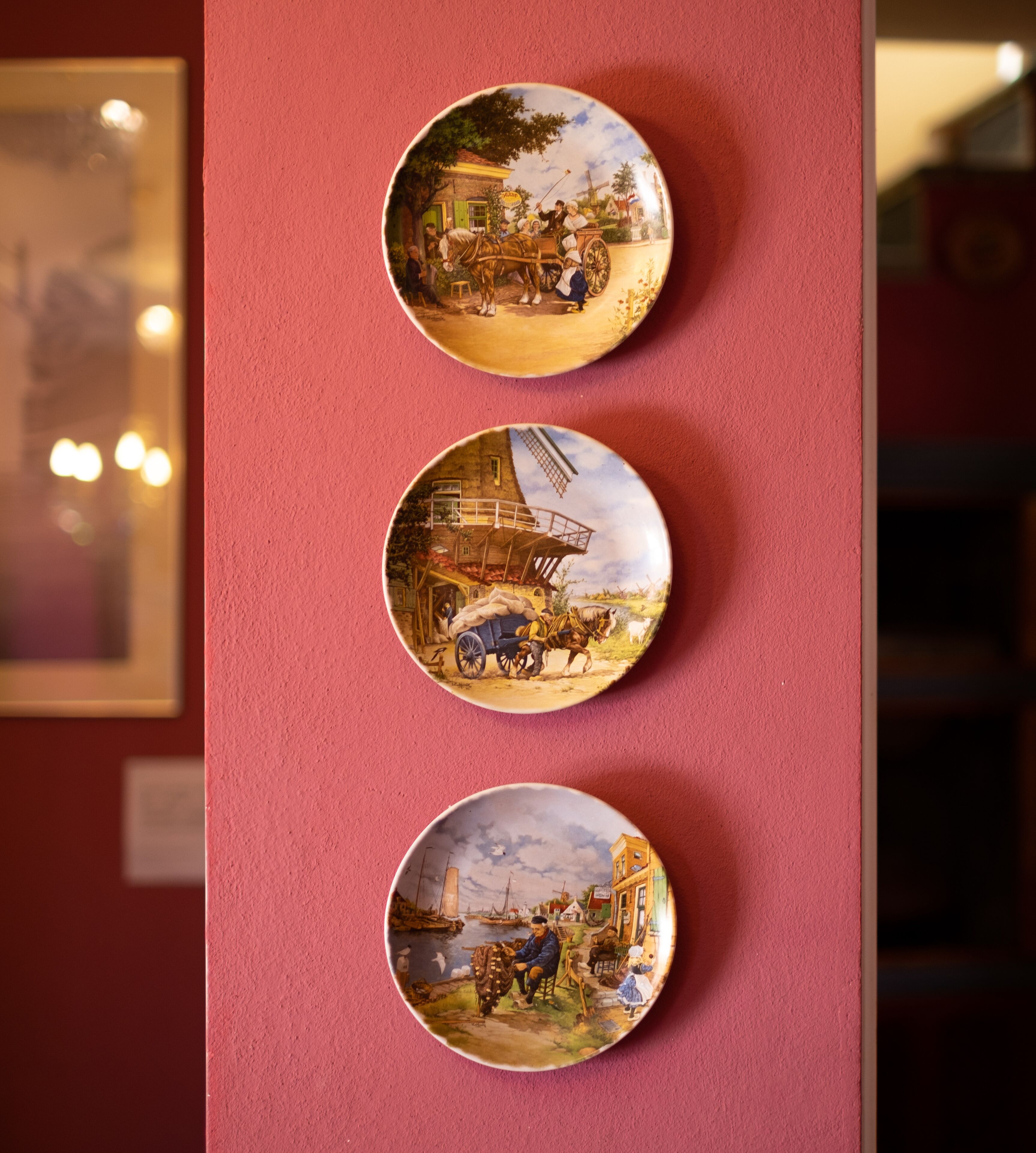 Three circular wall-mounted plates with historical scenes.