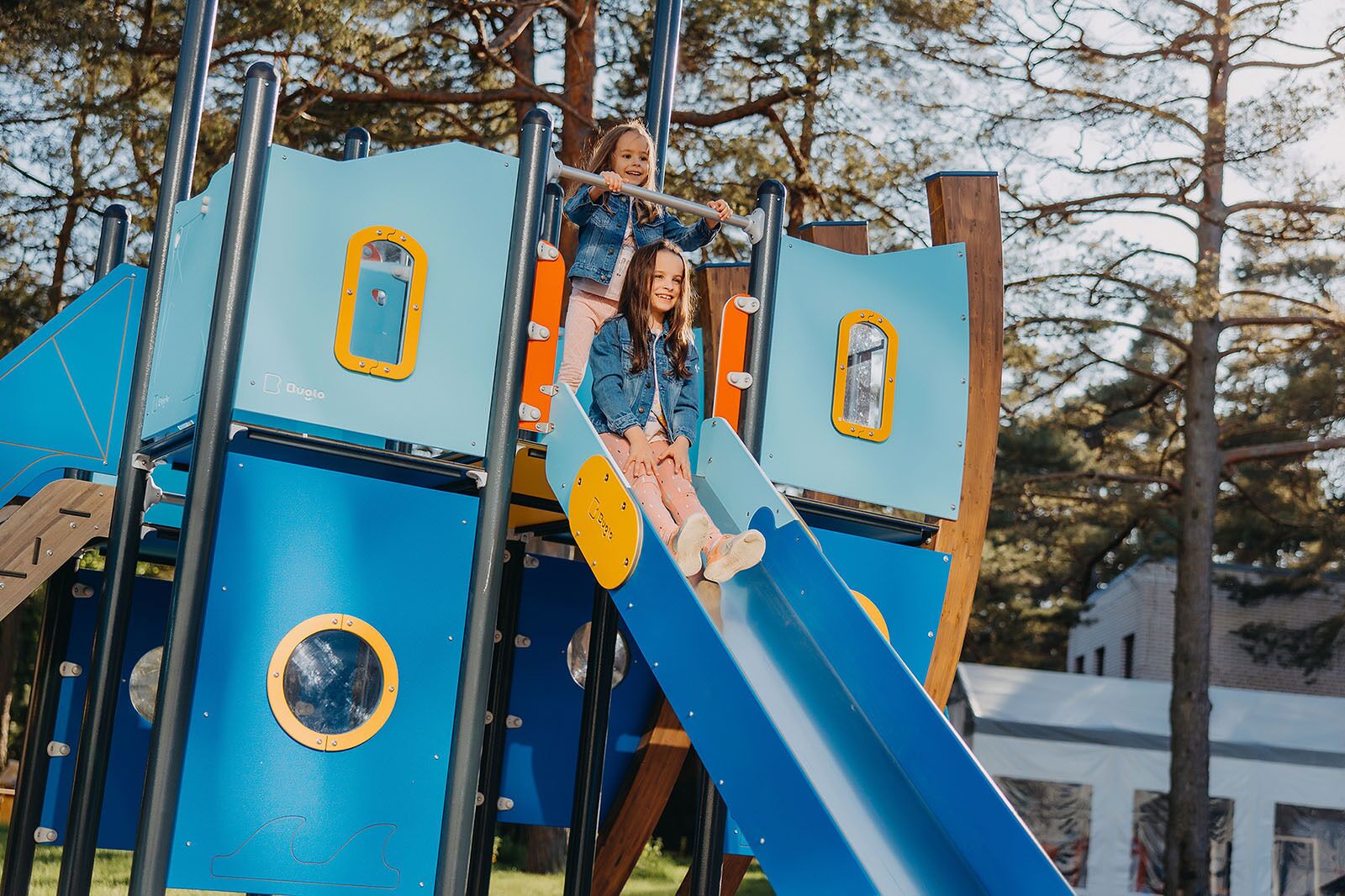 Un parque infantil con un tobogán azul y estructuras para escalar.