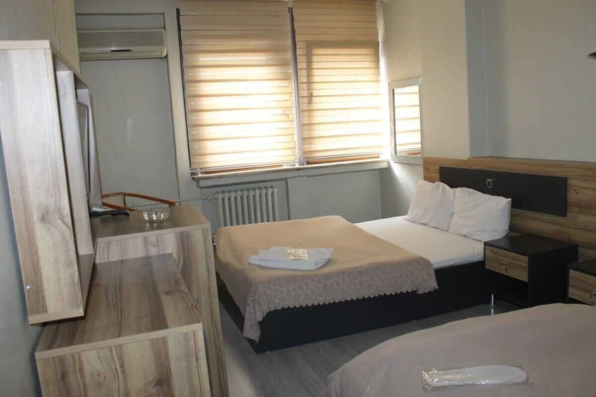 Una habitación de hotel con cama, mesita de noche y armario.