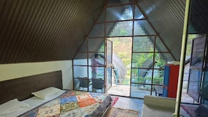 Une chambre avec un grand lit, une fenêtre et une vue sur l’extérieur.