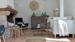 Ein Wohnzimmer mit Kamin, einer Couch, einem Couchtisch und einem Teppich.