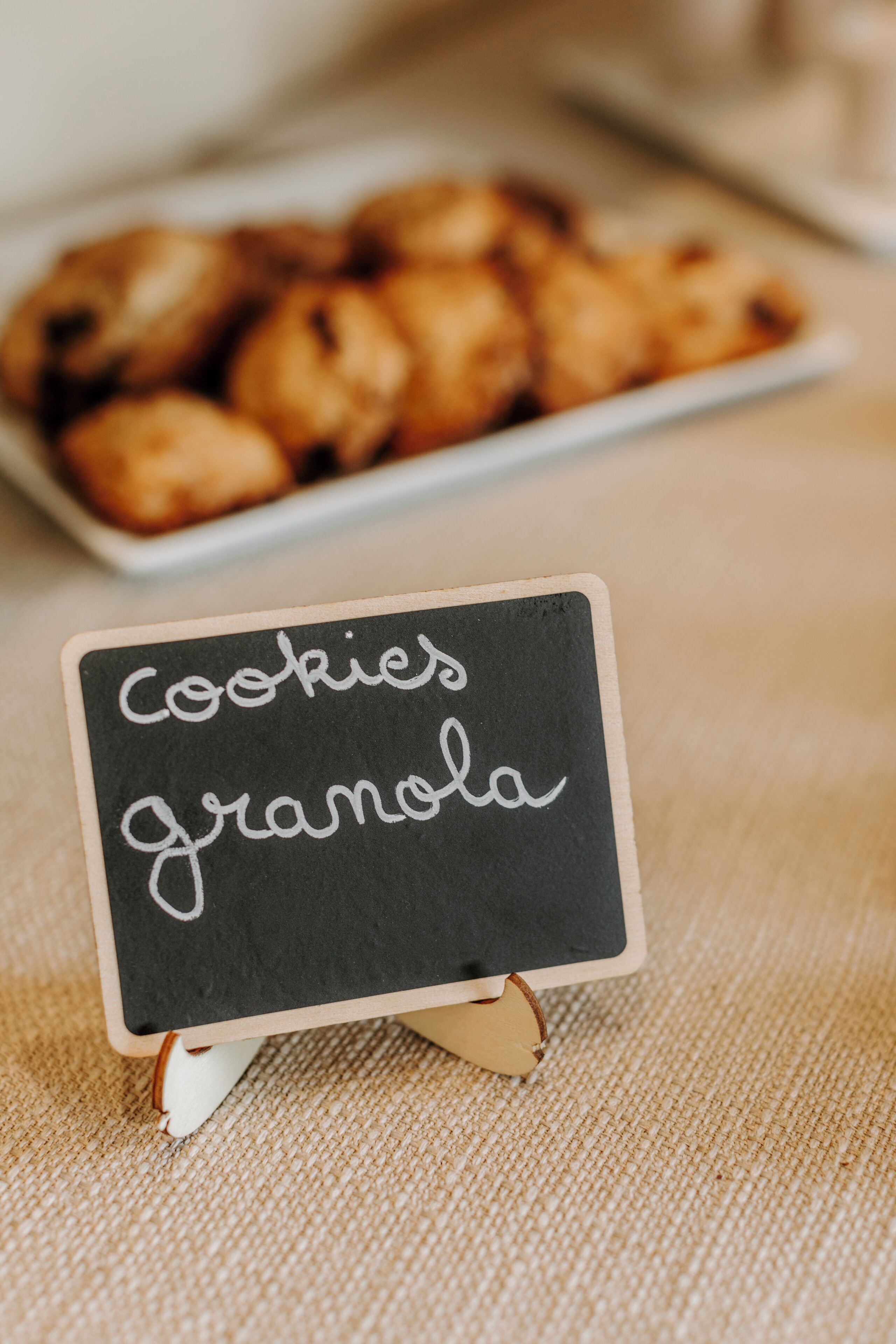 Un panneau noir avec le texte « cookies granola » écrit sur une surface texturée.