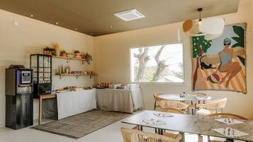 A dining area with a table, chairs, a refrigerator, and a microwave.