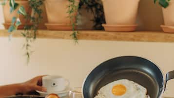 A breakfast setting with eggs, croissants, and juice on a table.