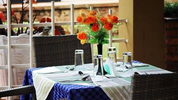 Enjoy a romantic dinner for two in this serene garden setting, complete with a beautifully set table and a stunning floral centerpiece.