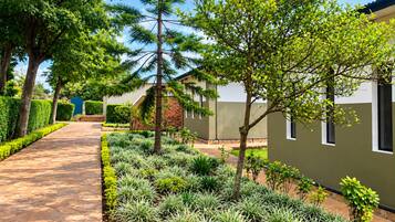 A pathway leading to a building with a garden in front.
