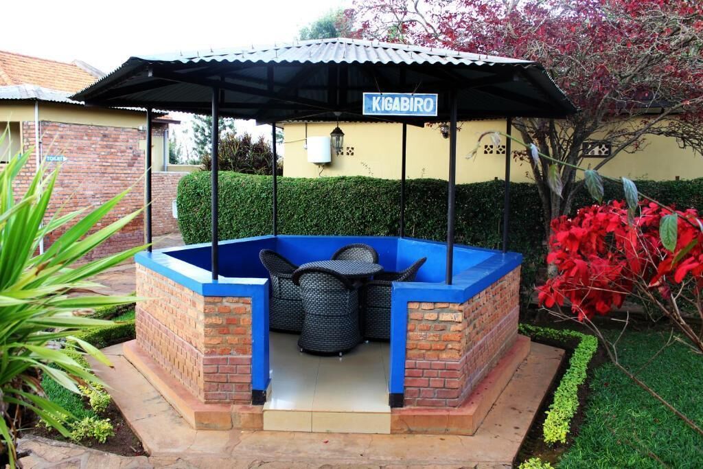 A covered outdoor seating area with a sign reading "KIGABIRO" and a brick structure.