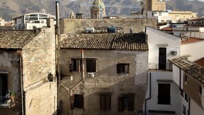 Vue d’une ville historique à l’architecture traditionnelle, avec notamment une église remarquable coiffée d’un dôme, ainsi qu’un ensemble de bâtiments résidentiels aux toits de tuiles.