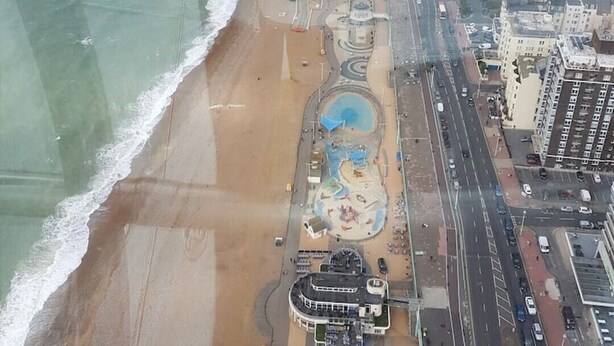 Vista aérea de una ciudad costera con playa, una glorieta y una combinación de edificios residenciales y comerciales.