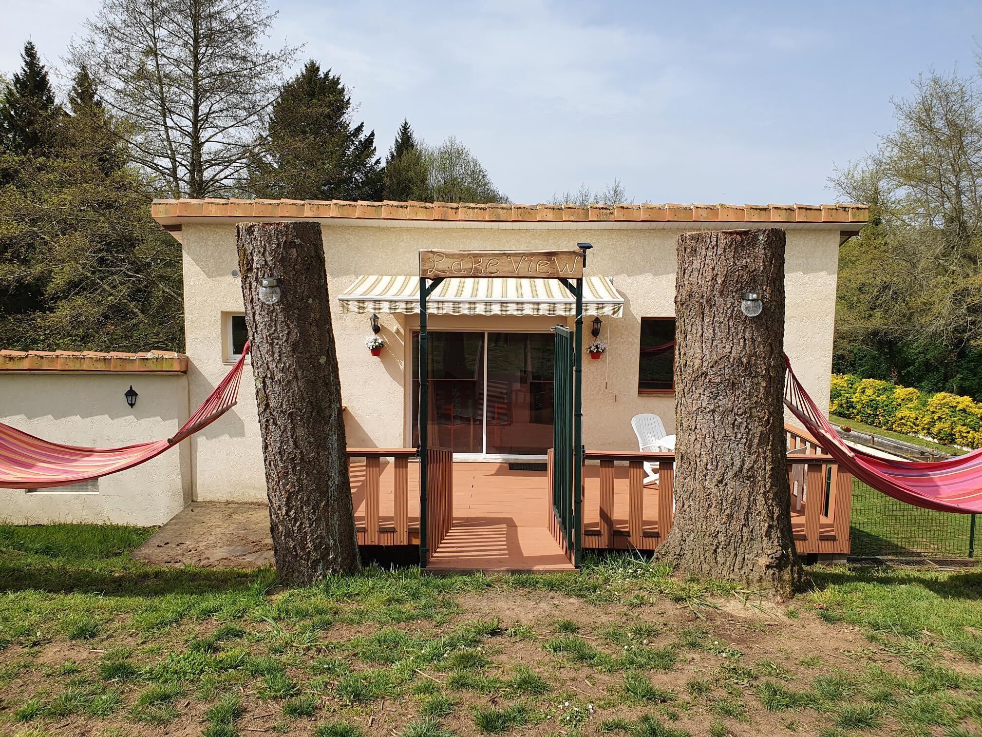 A small building with a patio area, a covered entrance, and a hammock.