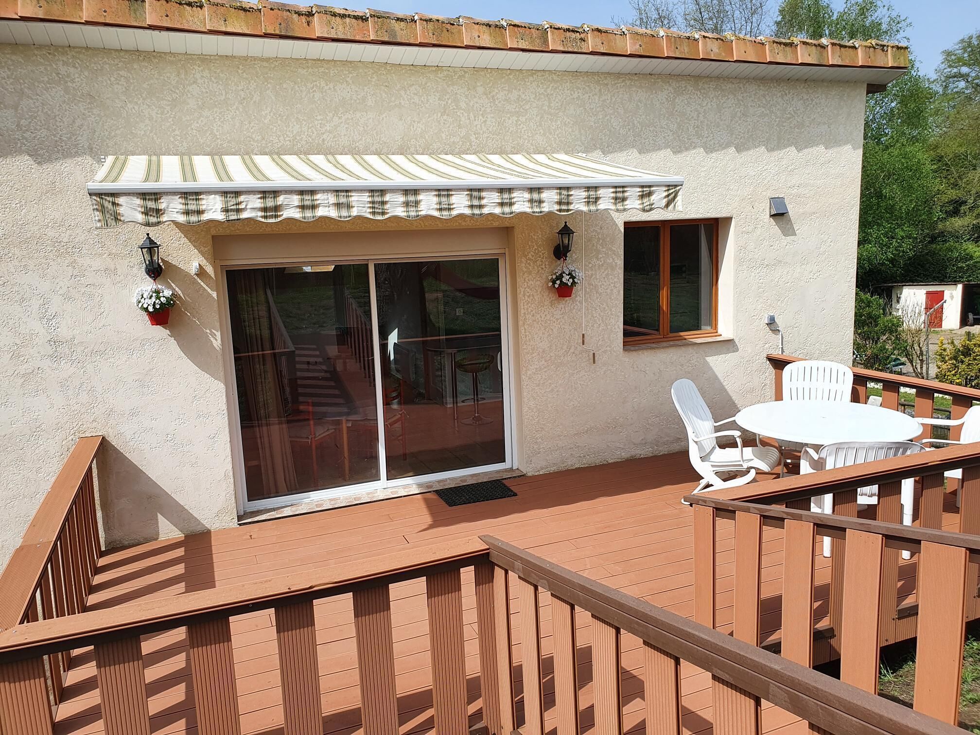 A patio with a white table and chairs, a sliding glass door, and a small window.