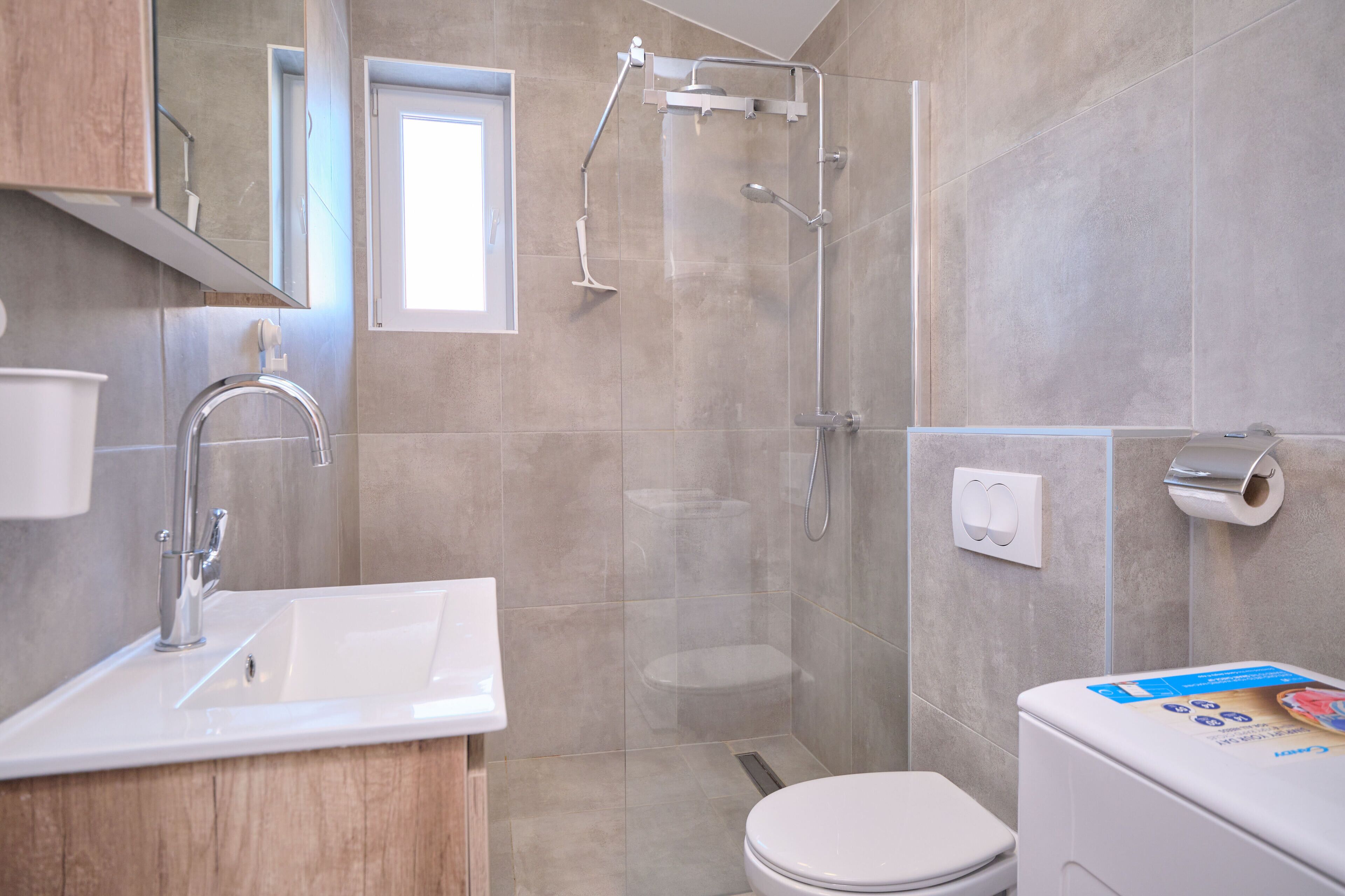 A modern bathroom with a sink, toilet, and shower.