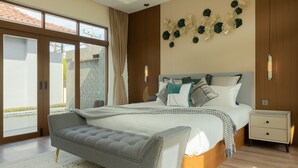Ein modernes Schlafzimmer mit einem großen Bett, einer Bank, einem Nachttisch und einem Wandbild.
