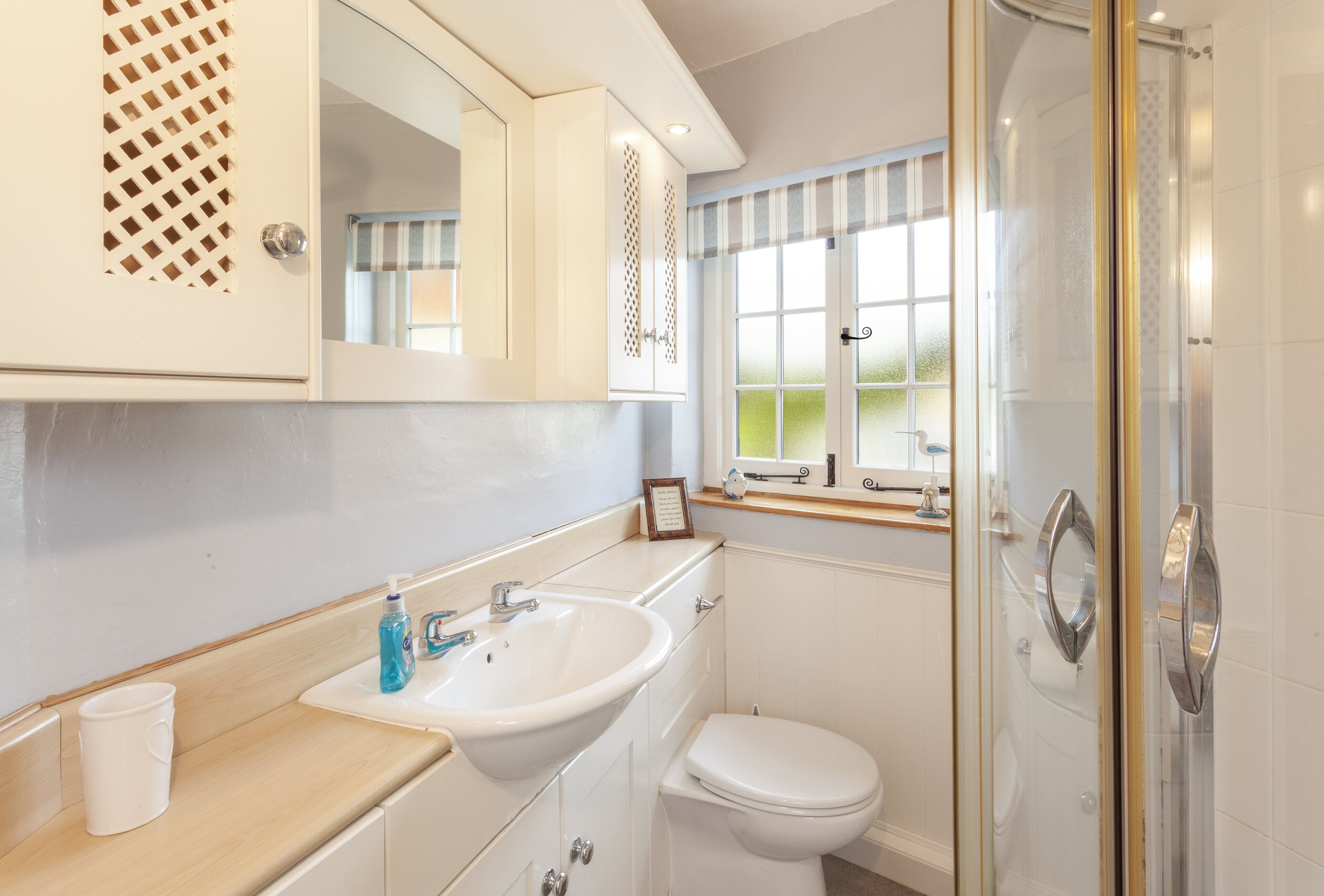 A bathroom with a sink, toilet, and shower.