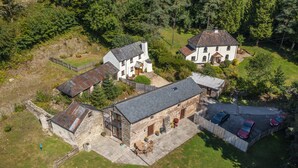 A large estate with multiple buildings, a stone house, and a paved driveway with cars. - Red Deer Cottage, Wheddon Cross (Wheddon Cross)