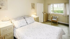 A bedroom with a bed, nightstands, a chair, a dresser, and a window with curtains. - Pine in Cleeve Park Near Blue Anchor (Near Blue Anchor)