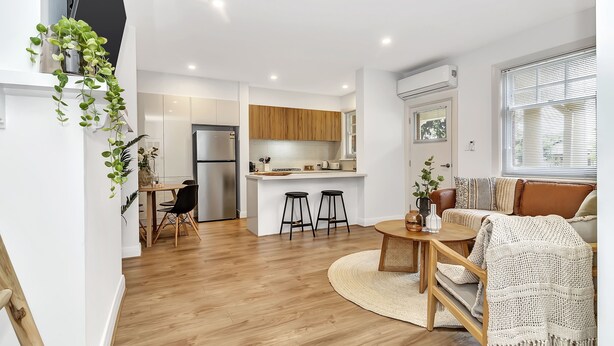 A modern apartment with a kitchen, dining area, and living room. - Glenelg Stay at The Bay (Glenelg South)