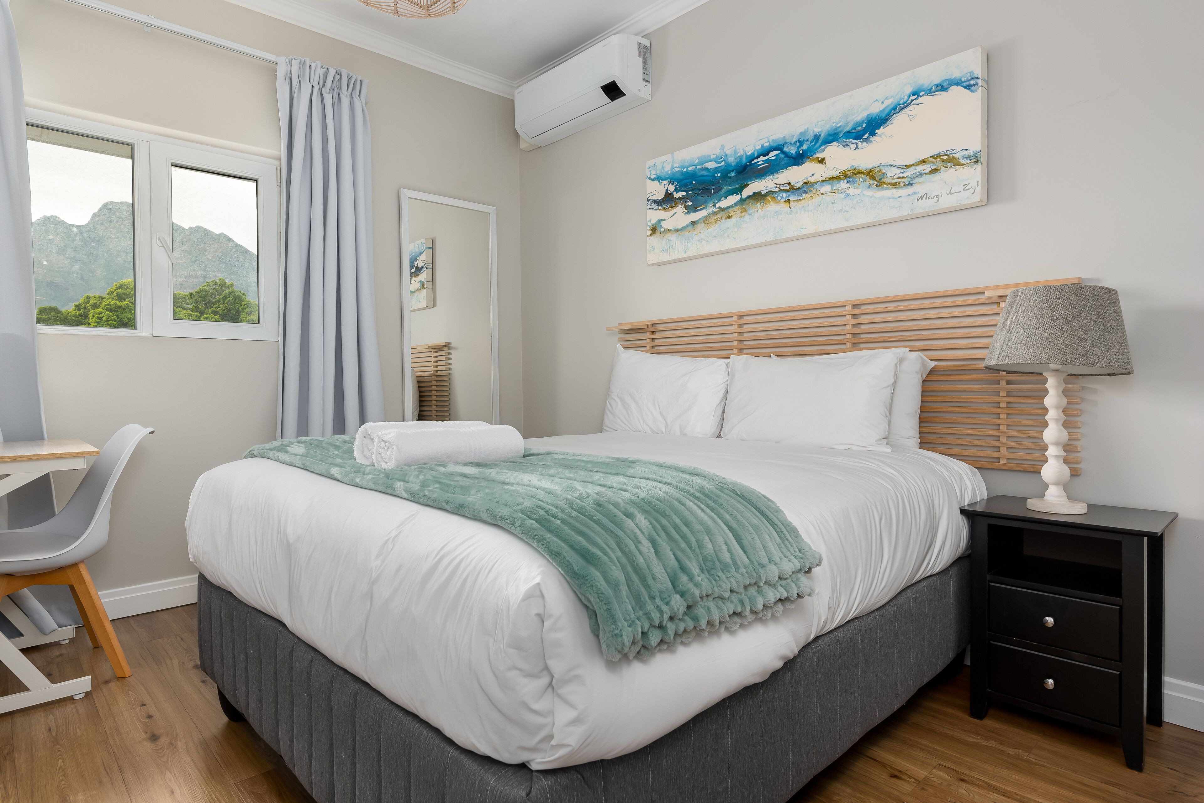 Una camera da letto con un letto, un comodino e una scrivania.