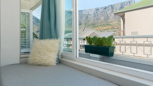 Een balkon met uitzicht op een berg en een gebouw.