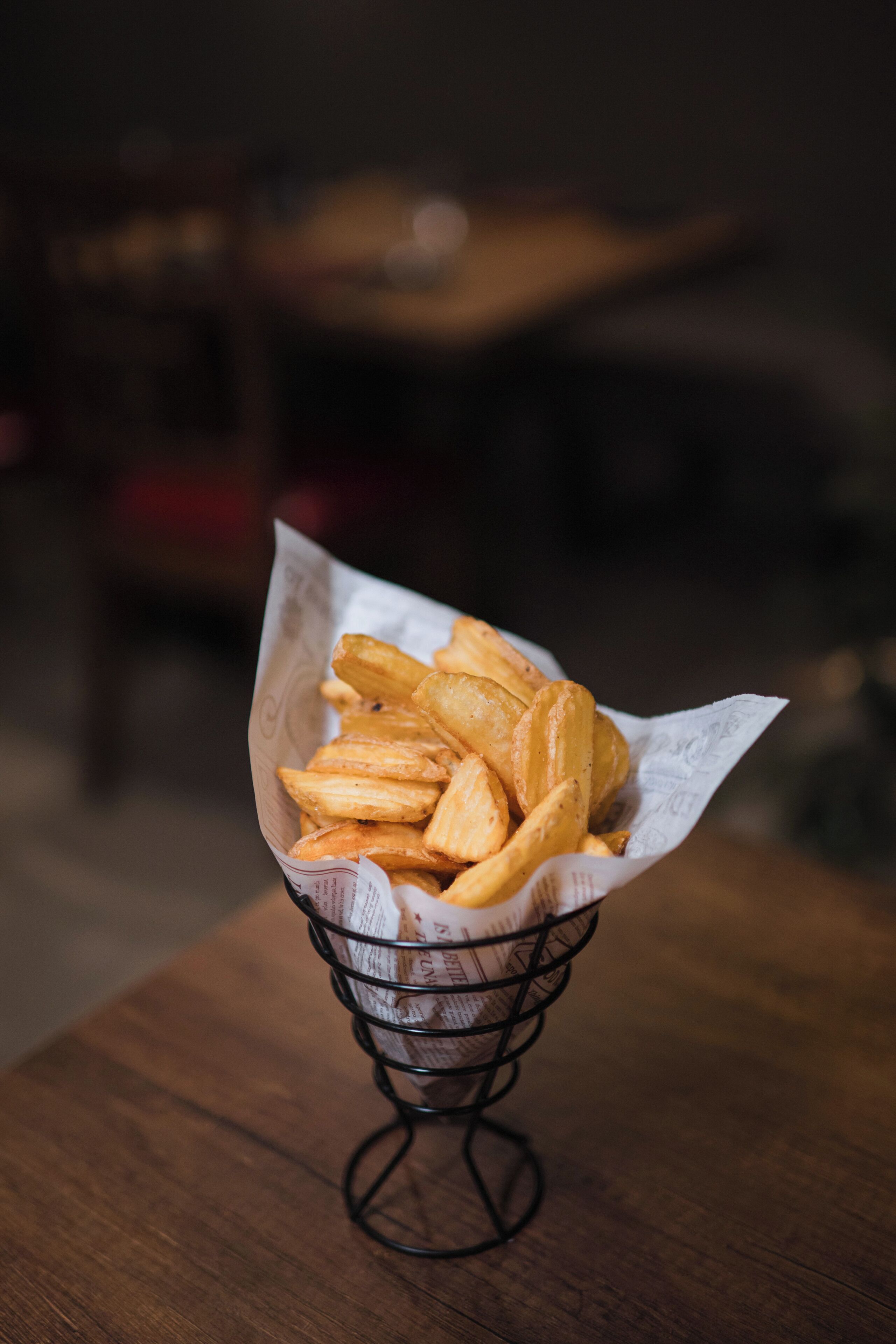 Un panier de frites sur une table en bois.