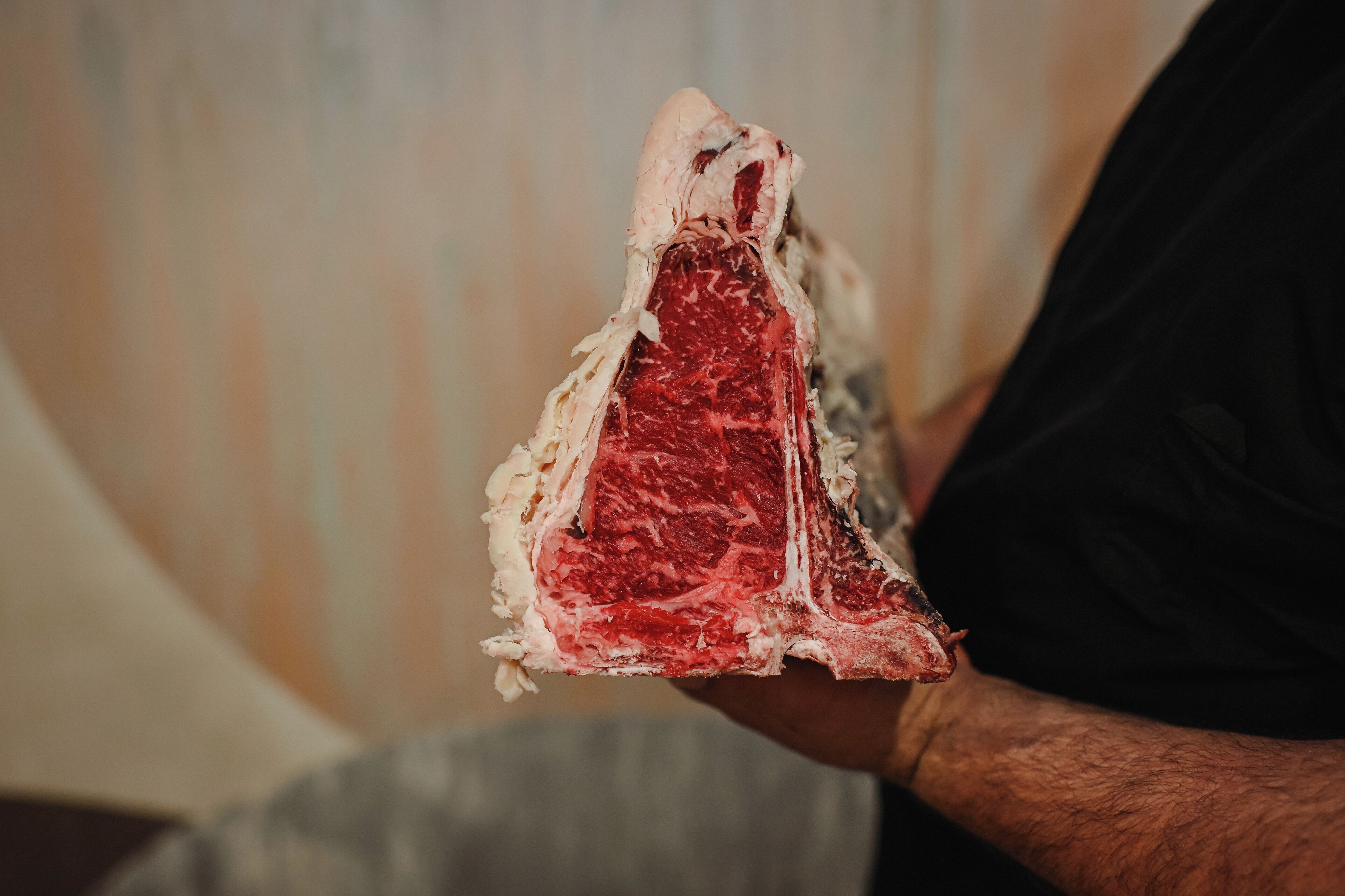 A person holding a large piece of meat.