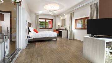 A modern hotel room with a large bed, a TV, a desk, and a bathroom with a shower.