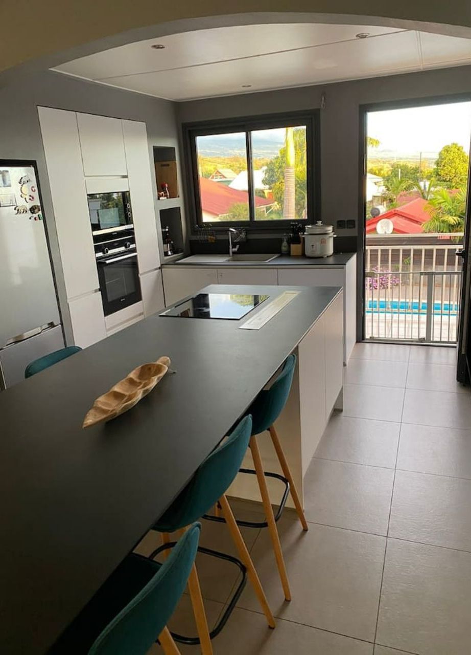 A modern kitchen with a central island, built-in appliances, and a view of the outdoors.
