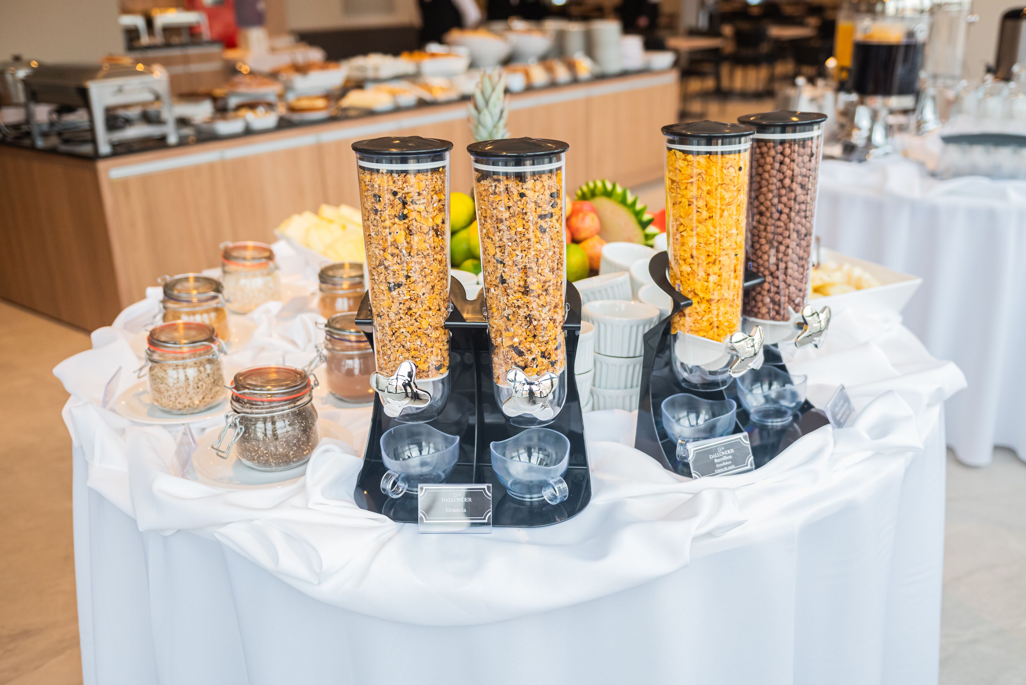 Disposição de buffet com diversos dispensadores de comida e potes de condimentos.
