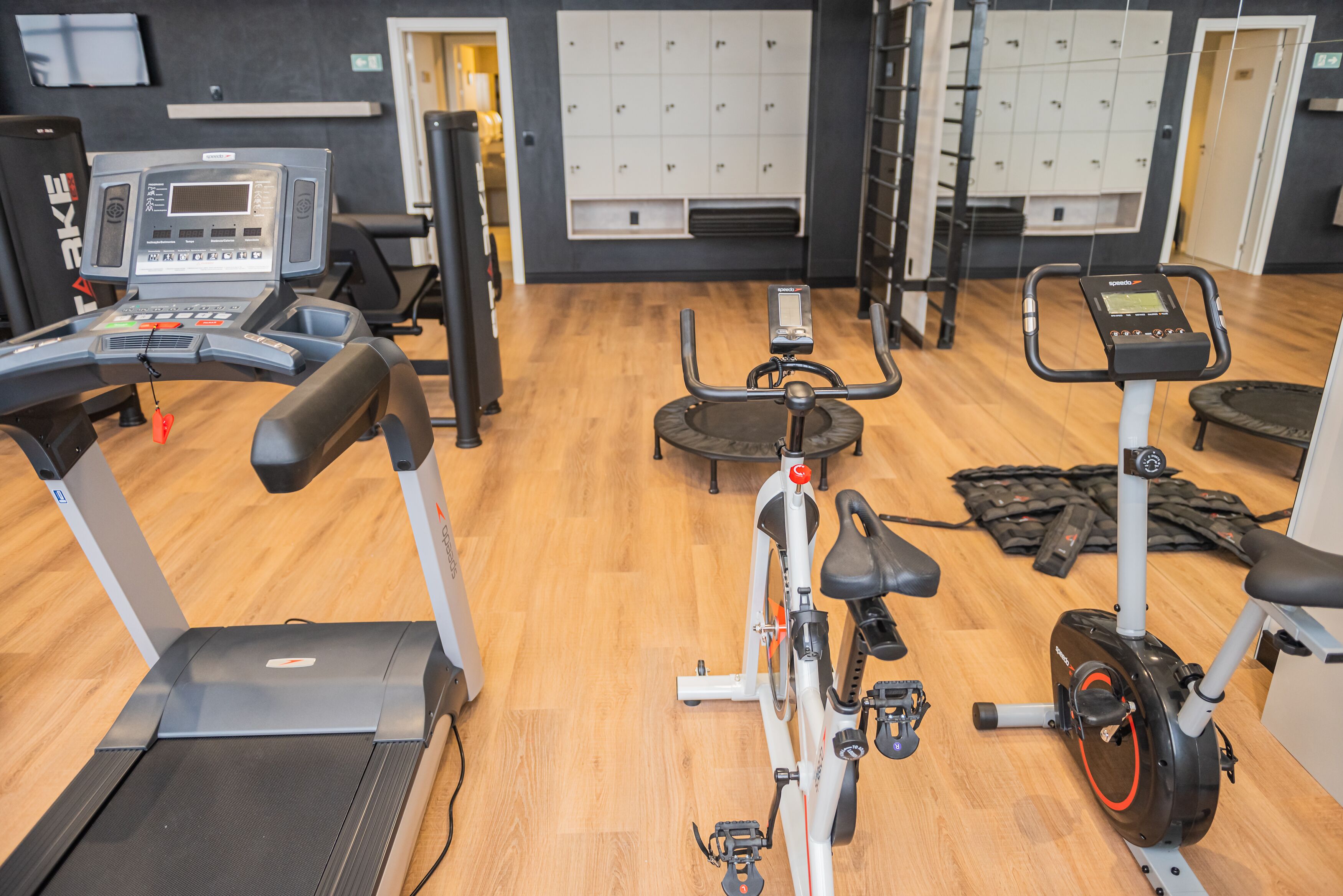 A gym with cardio equipment, weight machines, and lockers.