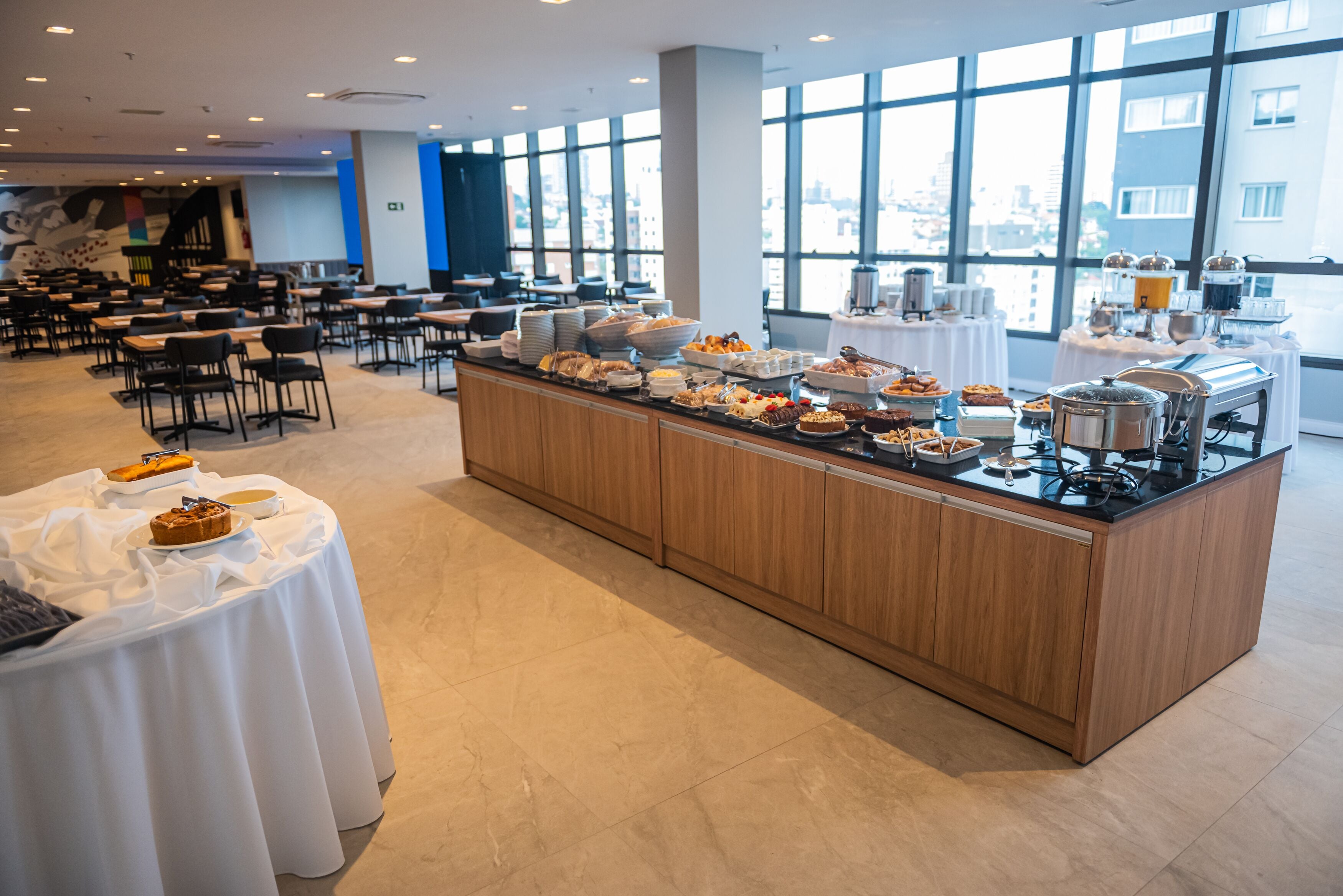 Un buffet proposant une vari été de plats, avec une vue sur la ville grâce à de grandes fenêtres.