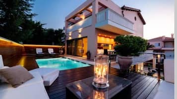 Alberca al aire libre y camastros