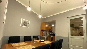 A dining area with a wooden table, black chairs, and a kitchen in the background. - Lares and Penates in Old Krakow,winter garden-5 min from the Rynok  Rynok Square (Kraków)
