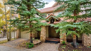 A house with a brick exterior, a red-tiled roof, and a front porch with a small staircase leading to the door. - Slopeside Chalet 3 Bedroom Townhouse by Alpine Lodging Telluride (Telluride)