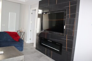 Een smart-tv, een open haard, boeken en een stereo