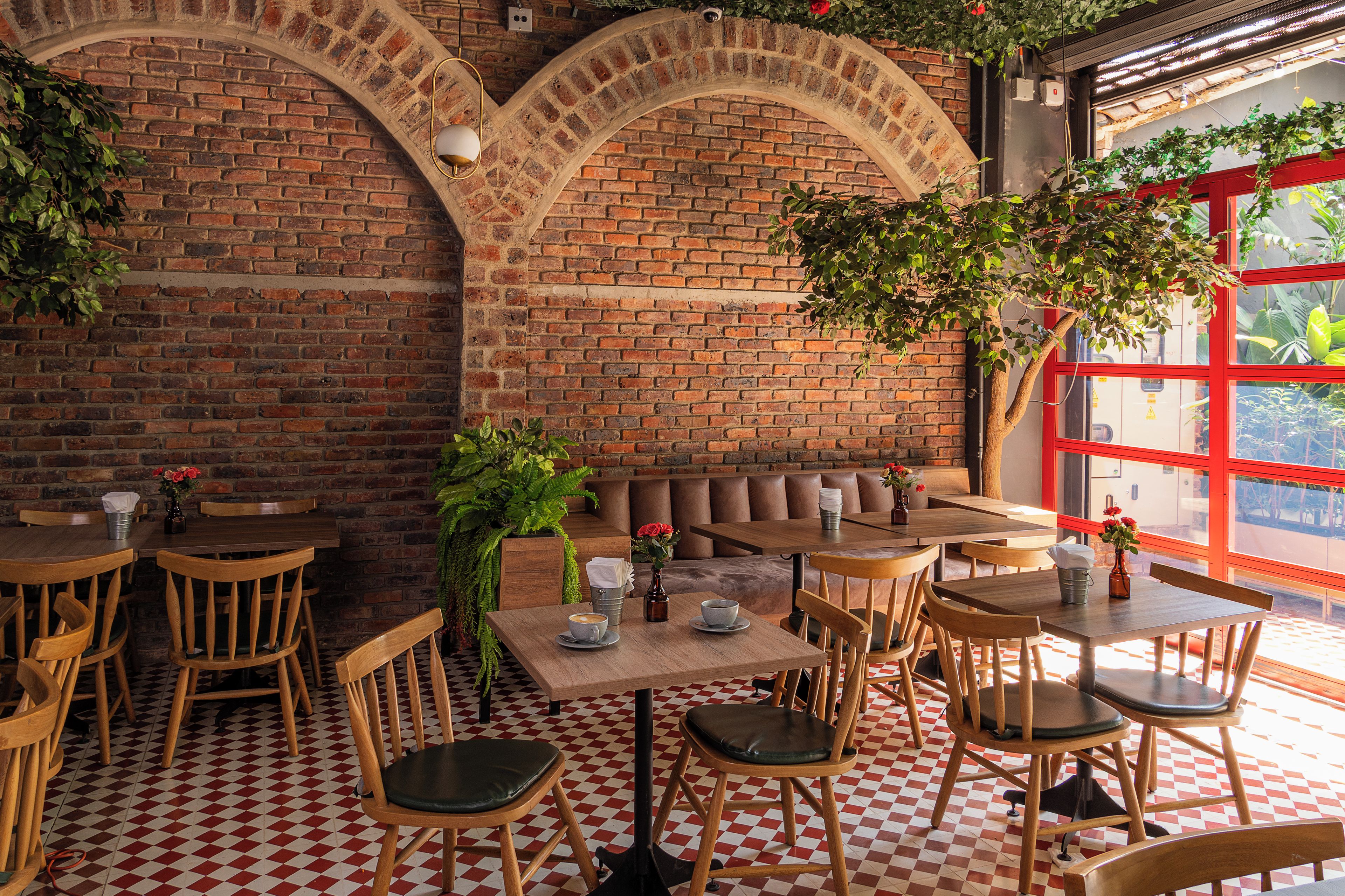 A restaurant interior with brick walls, wooden furniture, and a checkered floor.